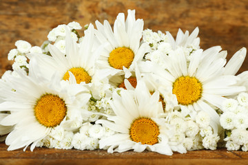 Beautiful chamomiles on wooden background