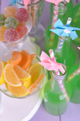 Bottles with drink and sweets on table  close up