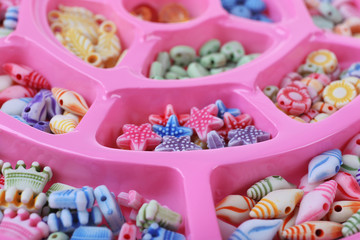 Obraz na płótnie Canvas Multicoloured beading kit for children in a pink box