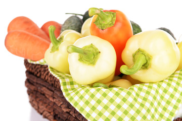 Yellow peppers with cucumbers in basket close up