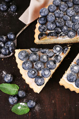 Tasty homemade pie with blueberries on wooden table