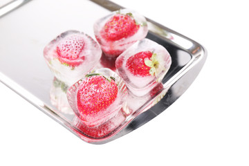 Ice cubes with strawberry on tray isolated on white