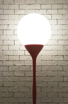 Lamp with circle shape on white bricks background vertical
