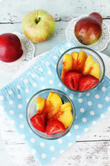 fresh tasty fruit salad on blue wooden table