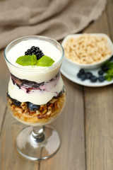 Natural yogurt with fresh berries on wooden table