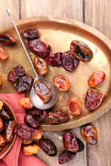 Tasty dates fruits on old metal tray, on wooden background