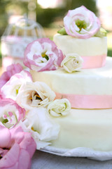 Obraz na płótnie Canvas Beautiful wedding cake with flowers on table, outdoors