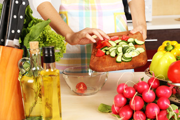 Woman cooking vegetable salad in kitchen