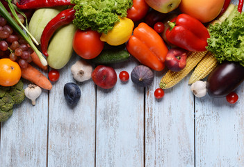 Fresh organic fruits and vegetables on wooden background