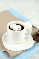Hot chocolate with marshmallows in mug, on wooden background