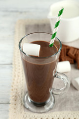 Chocolate drink with marshmallows in mug, on wooden background