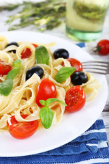 Fototapeta na wymiar Spaghetti with tomatoes, olives and basil leaves