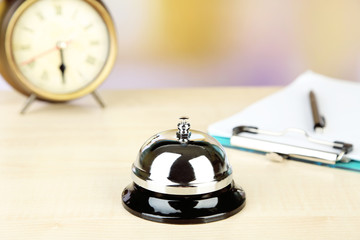 Reception bell on hotel reception desk, on bright background