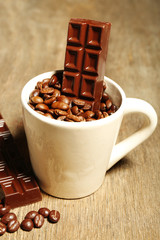 Cup with coffee beans and dark chocolate glaze