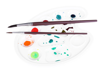 Fototapeta na wymiar Multicoloured paint and brushes on palette isolated on white