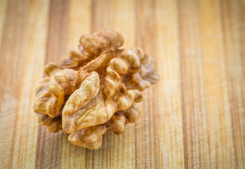 Kernel walnut on wood background. Selective focus.