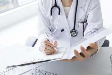 Female doctor writing a medical certificate