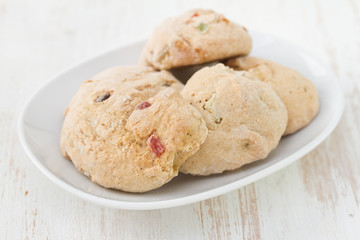 cookies with dry fruits on dish on white background