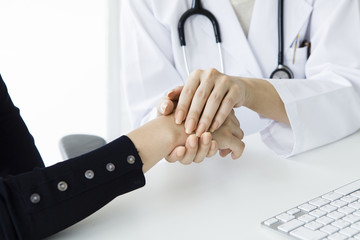 Female doctor holds the patient's hand