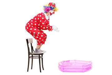 Male clown preparing to jump into a small pool