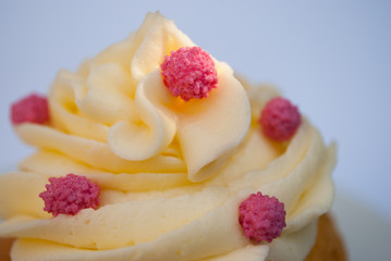 Macro of a buttercream toping with three candies on top.