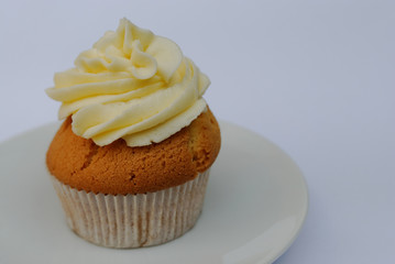 Cupcake with buttercream on a plate.