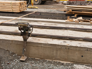 Ein Ministampfer lehnt an einem Betonfundament