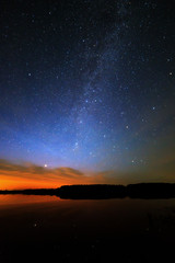 Morning dawn on a starry background sky reflected in the water o