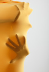 abstract hands, human arm inside yellow fabric, studio shot