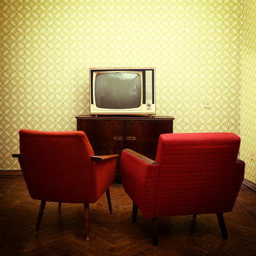 Vintage room with two old fashioned armchairs and retro tvover o