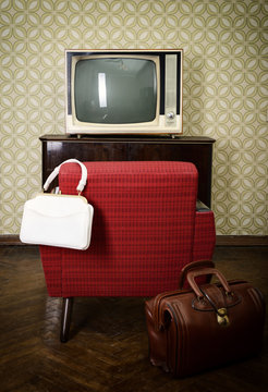 Vintage room with wallpaper, old fashioned armchair, retro tv an