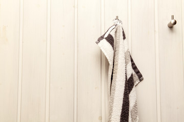 Handtuch hängt an einer Holzwand am Haken