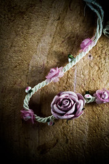 vintage of artificial flowers rose on the old paper stripes.