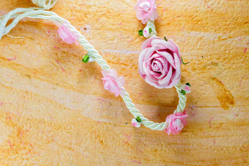 vintage of artificial flowers rose on the old paper stripes.