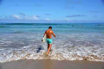 surfista entrando al mar