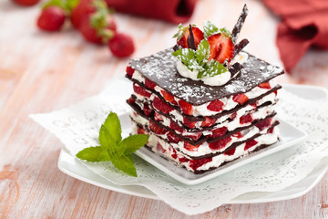 Chocolate dessert with strawberries, whipped cream and mint.