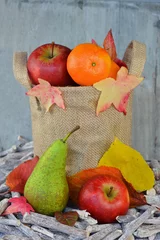 Tapeten herfstfruit in jute zak met herfstbladeren © trinetuzun