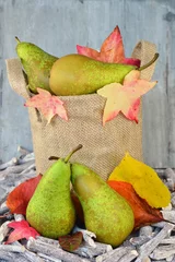 Tapeten Peren in een jute zak met herfstbladeren © trinetuzun