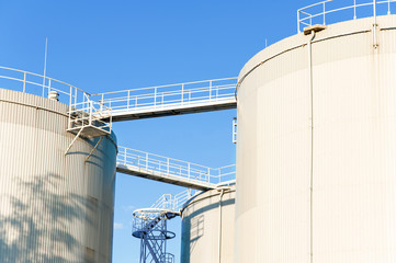 Three petrol tanks on blue sky background. Storage in Riga.