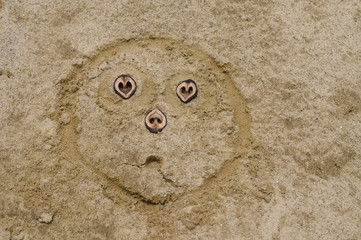 In den Sand gezeichnetes mitleiderregendes Gesicht