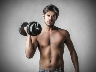 Fototapeta na wymiar Young man lifting weights