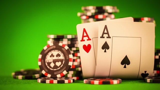 Stack of chips and two aces on the table on the green baize 