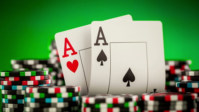 Stack of chips and two aces on the table on the green baize 