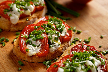 Bruschetta with  tomato,  cheese  and fresh chive