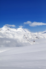 Winter snowy mountains and ski slope at nice day.