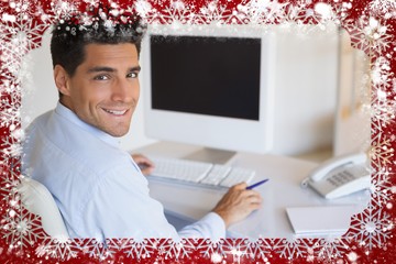 Casual businessman at desk smiling at camera