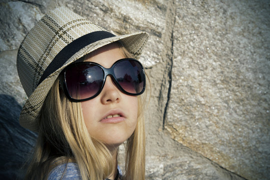 Long-haired girl in hat and sunglasses, portrait