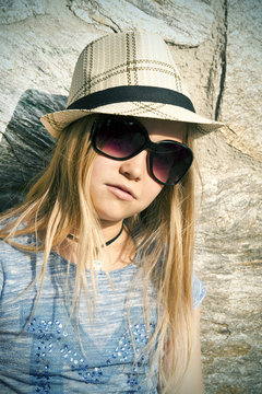 Long-haired girl in hat and sunglasses, portrait