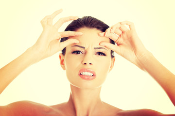 Woman checking her wrinkles on her forehead