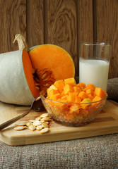 Pumpkin, diced for cooking recipe and a glass of milk.